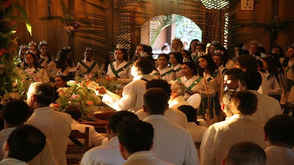 A Santo Daime gathering in white dress with green sashes in a church-like setting