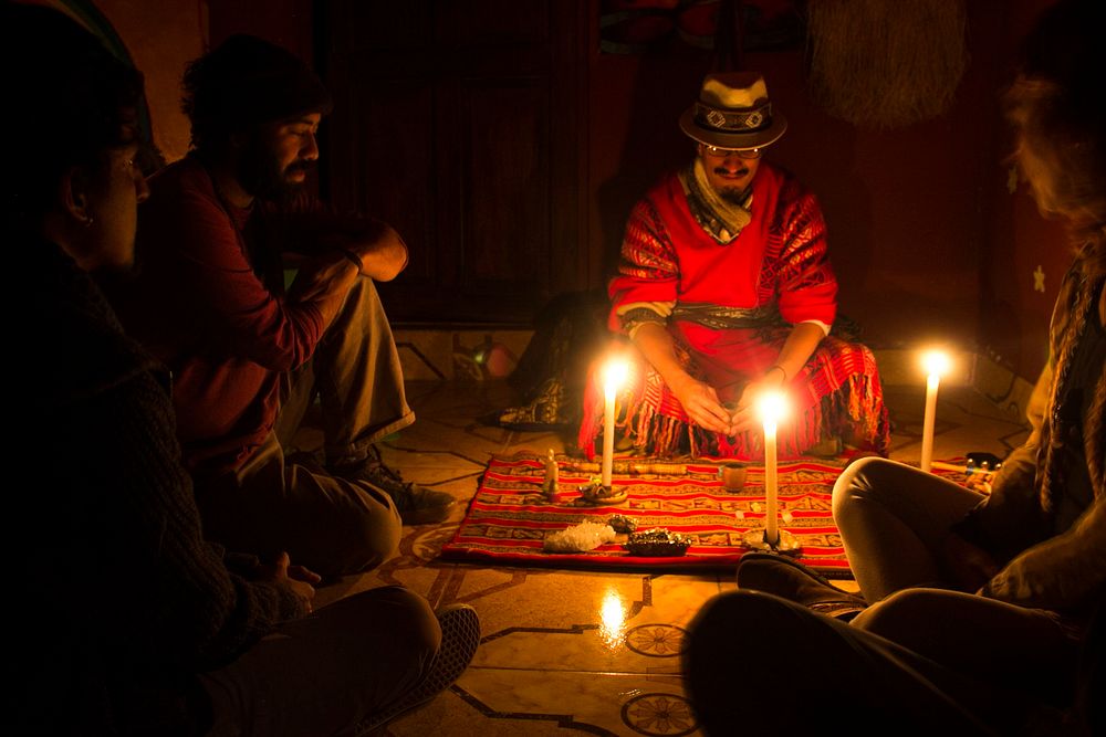 A candlelit Amazonian ayahuasca ceremony led by an ayahuasquero in traditional dress